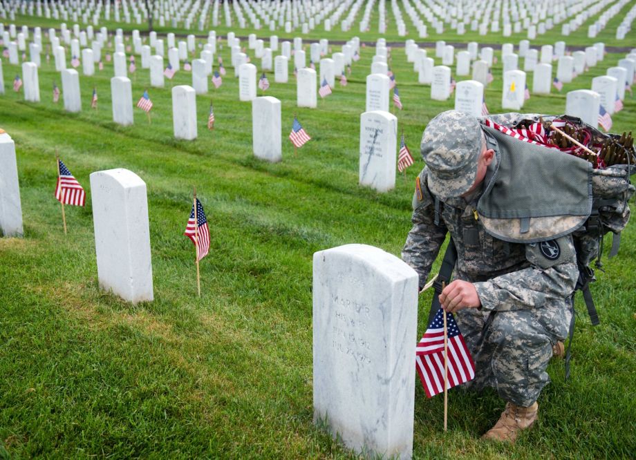 A U.S. Army 3d U.S. Infantry Regiment (The Old Guard) Soldier places American flags at headstones in Section 64 of Arlington National Cemetery during Flags In, May 21, 2015, in Arlington, Va. The Old Guard has held this honor and privilege of conducting Flags In since 1948.