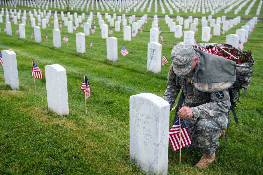 A U.S. Army 3d U.S. Infantry Regiment (The Old Guard) Soldier places American flags at headstones in Section 64 of Arlington National Cemetery during Flags In, May 21, 2015, in Arlington, Va. The Old Guard has held this honor and privilege of conducting Flags In since 1948.